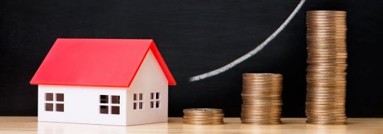 Toy house and dollar coins | Canstar