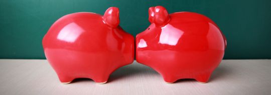 Two piggy banks kissing