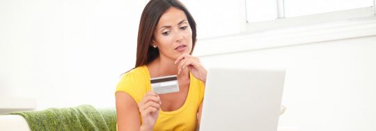 Woman thinking, holding a credit card | Canstar