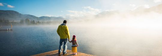 Father and Daughter Standing on Dock Looking Over Lake