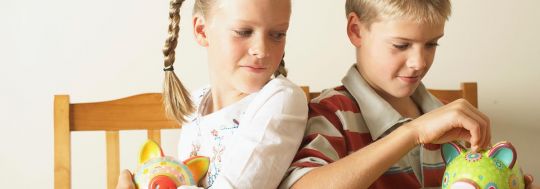 Two kids putting money in a piggy bank | Canstar