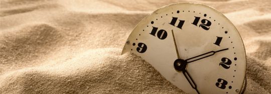 Sand with a clock face in it to signify passing time