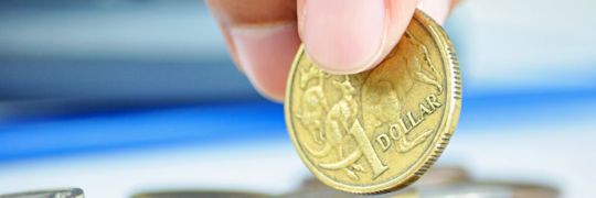 Holding a single dollar coin