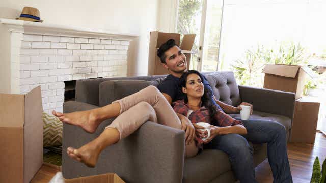 A couple takes a break from moving into their new home.