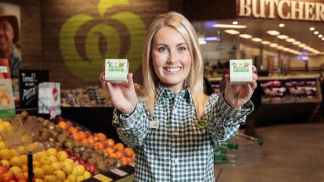 A Woolworths employee holding Discovery Garden packs.