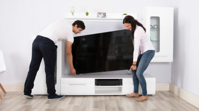 Couple installing a TV.