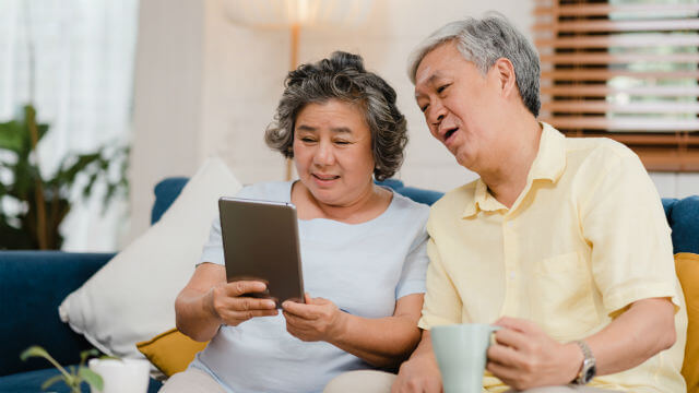 A mature couple examines their bank balance online. 