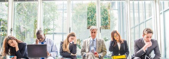 Several Professionals Sitting On Bench Waiting