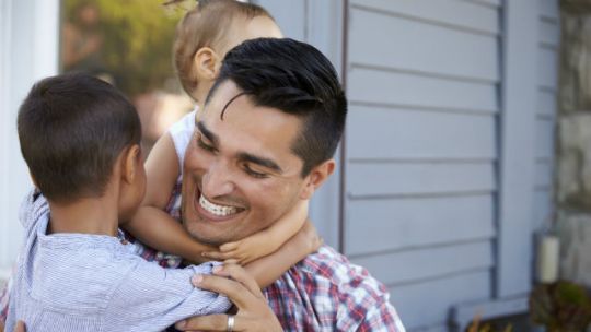 Happy Family Hugging Outside A House