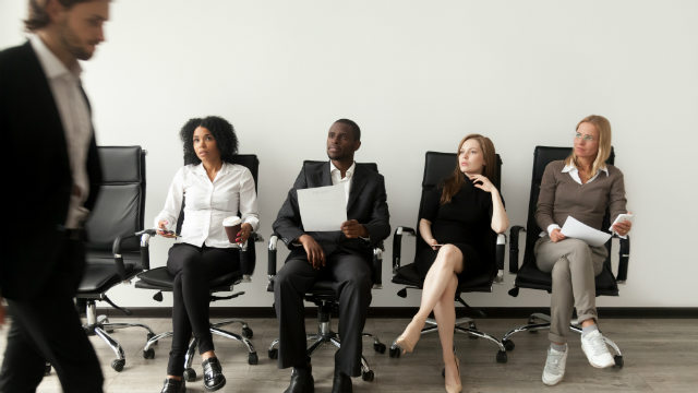 Job seekers wait in line for an interview