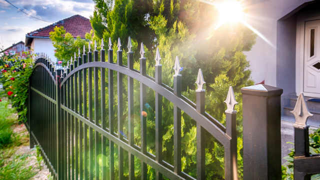 An image of a cast iron fence outside a house