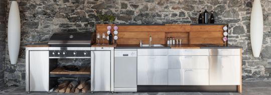 Outdoor kitchen featuring hanging lights and a slate wall