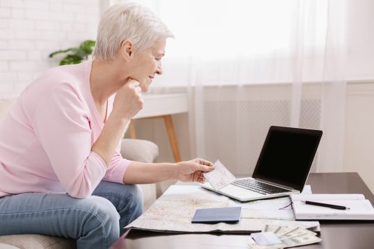An older lady researching on a laptop