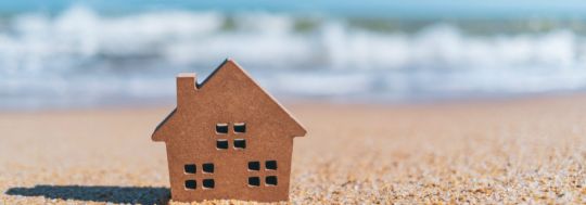 House with a wave in background
