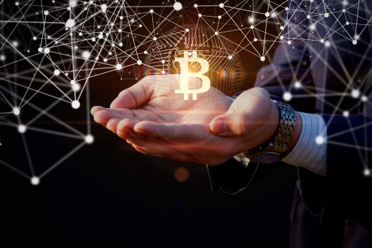 BitCoin Symbol above hands