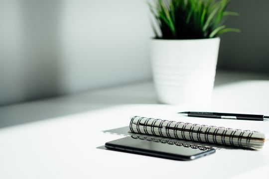 Phone and Notebook sitting on desk