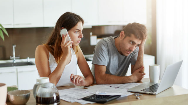 Couple experiencing financial hardship on a phone call.