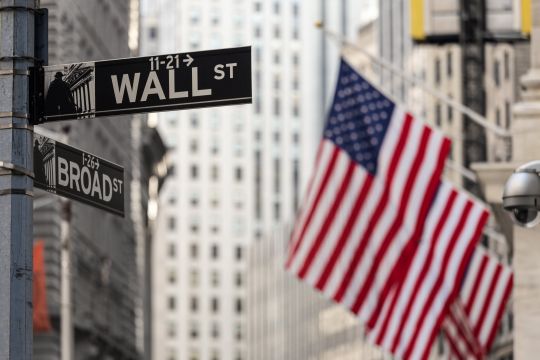 Wall street sign and American flag