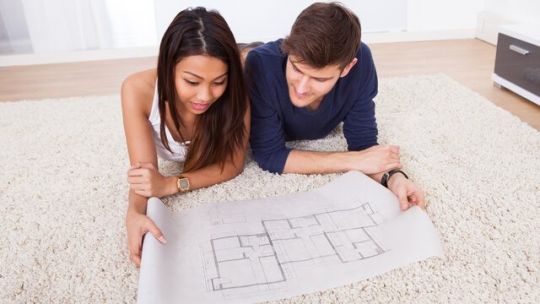 A young couple looks at house plans