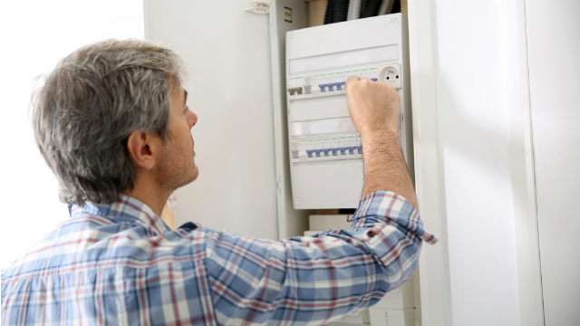 Man using electricity box in home
