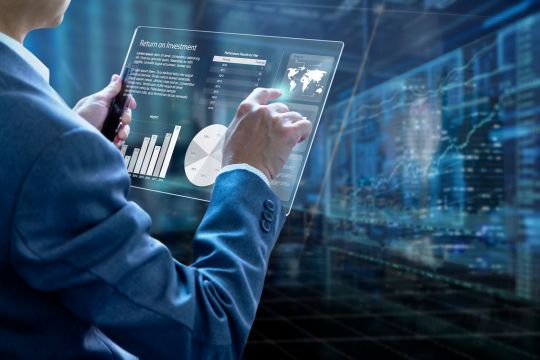 Man holding tablet with graphs