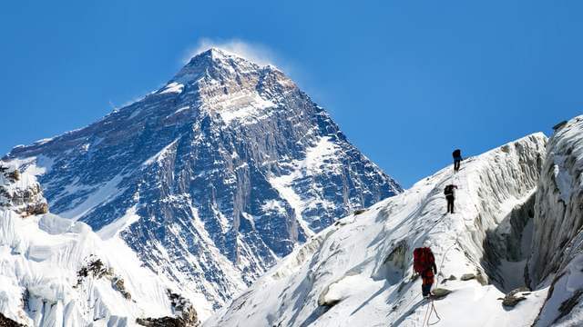 Three mountain climbers make their way up Mt Everest