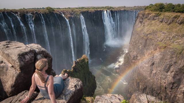 A woman sits atop of Victoria Falls, Mosi-o-tunya Road, Livingstone, Zambia