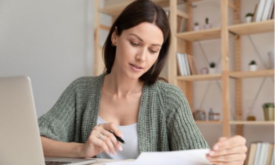 Woman on laptop reviewing documents