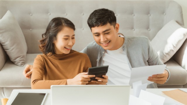 Young couple with calculator & laptop