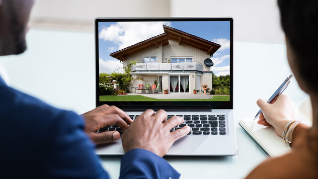 Two people sitting at computer looking at a property