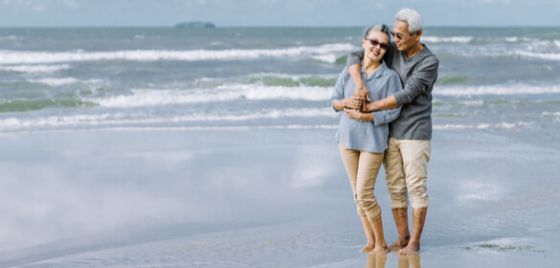An elderly couple walking on a beach