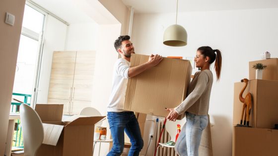 Two people lifting a box