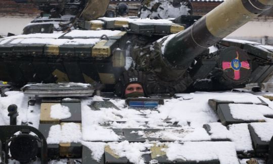 A tanker peeps out of the hatch of a Ukrainian T-64 tank