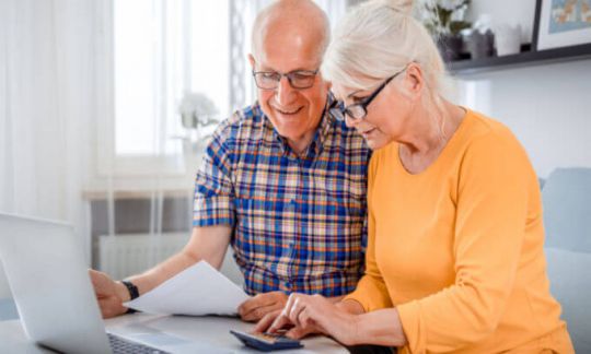 An elderly couple check their super balance
