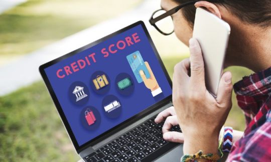 Someone checking their credit score via a laptop