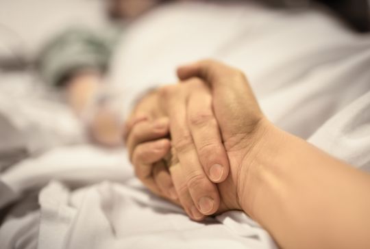 A couple holding hands in a hospital