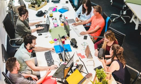 A busy workplace with lots of people using computers
