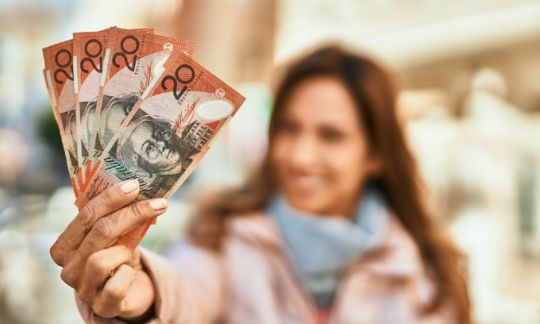 A woman holding a bunch of $20 notes