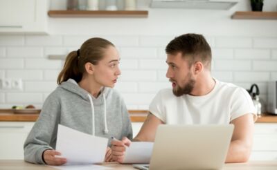 A couple looking at some paperwork, representing the title, "Bad credit personal loans: what to watch out for?"