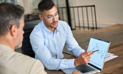 A financial advisor shows an investment chart to a client representing financial advisor fees.