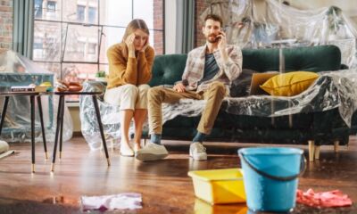 A couple sit on a couch with a leaky roof and wonder how to make a home insurance claim.