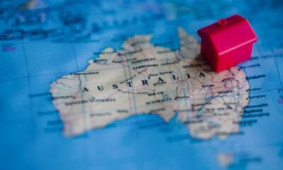 A red house sits on top of a map of Australia.