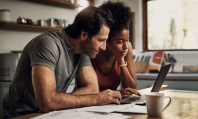 A couple looks at a laptop screen representing how much can I borrow home loan.