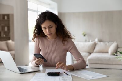 A lady sitting with some papers, representing the title, 'How to get a tax deduction for interest on a home loan'