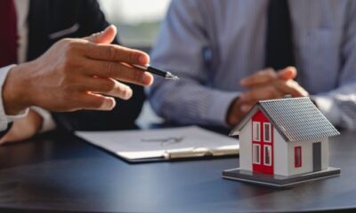 An image of two individuals signing a document representing the title, 'How to switch insurance providers?'