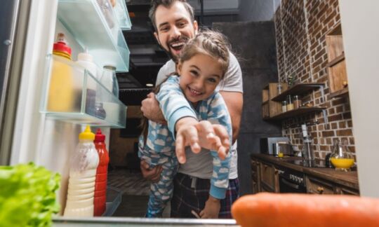 A father keeps his daughter out of the fridge and contemplates motor burnout cover.