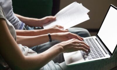 A couple checking through documents and using a laptop representing personal loan protection insurance.