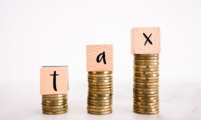 Blocks that spell out 'tax' sit on stacks of gold coins representing no tax free threshold.
