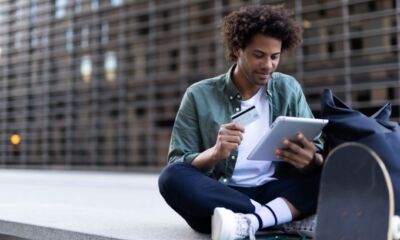 A student uses his credit card to buy something online representing student credit cards.