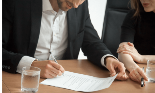 A young man signing paperwork as he starts a new job